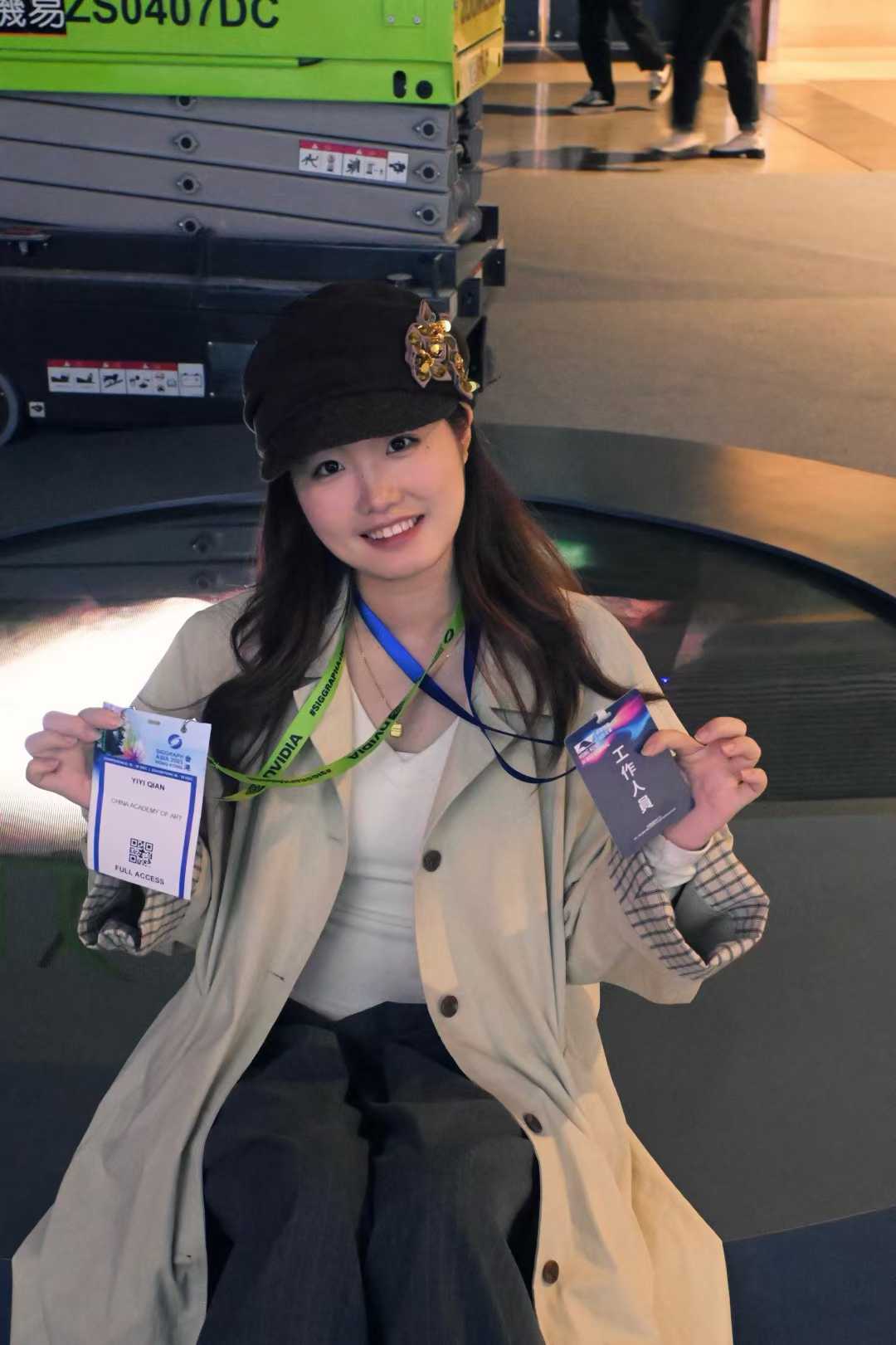 Yiyi Qian holding event badges at the Hong Kong International AI Art Festival