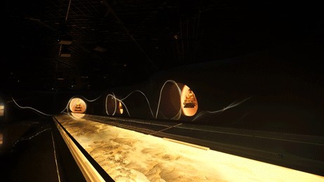 Long illuminated mountain handscroll extending through the dark exhibition space