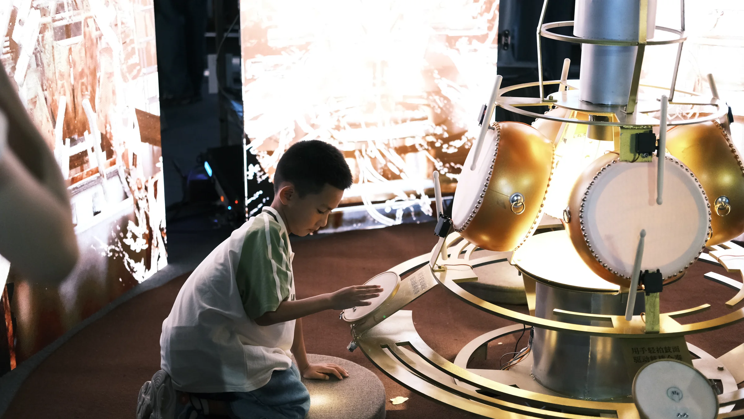 A visitor reaching toward one of the central frame drums