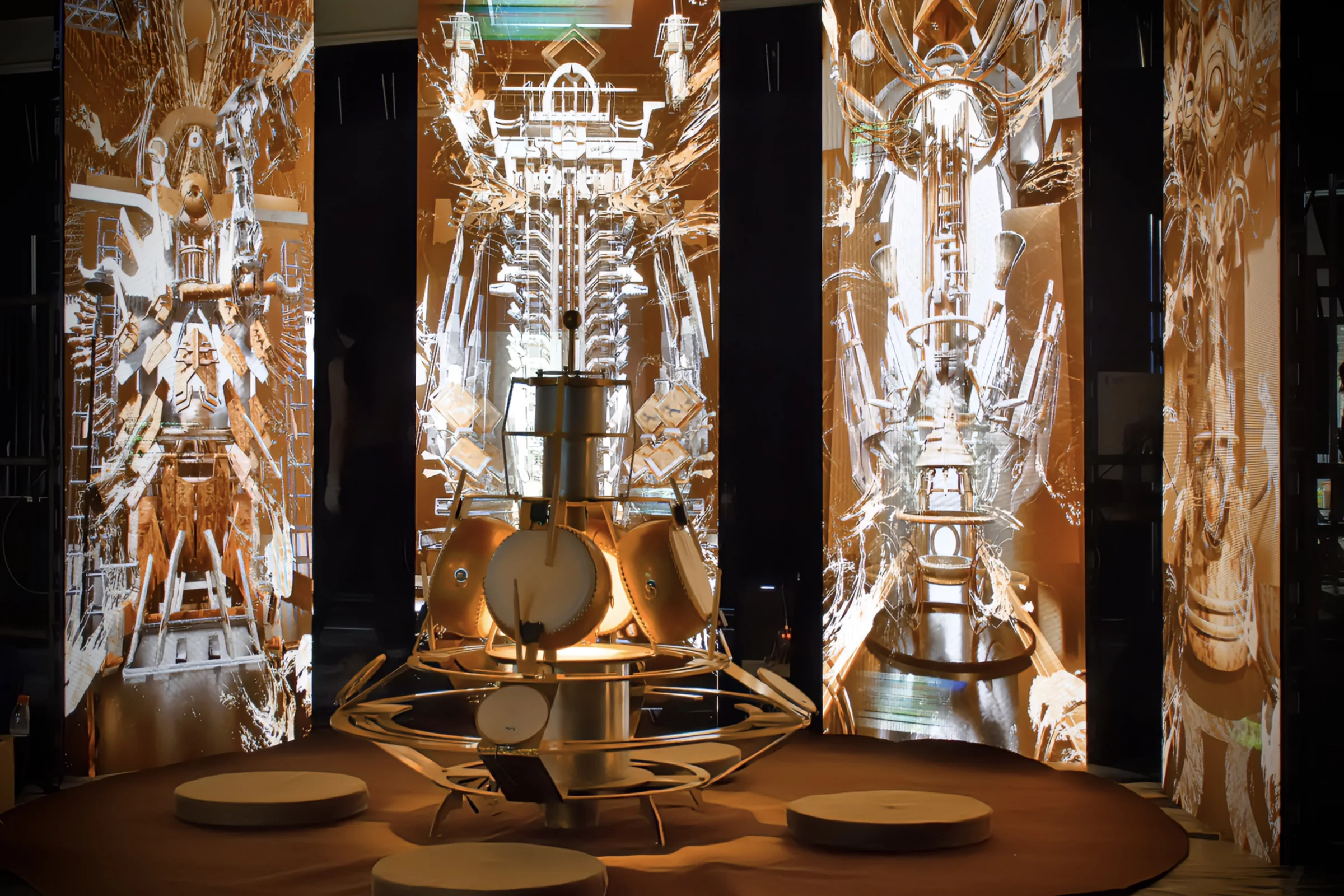 Wide installation view showing the circular frame drum and four illuminated image panels